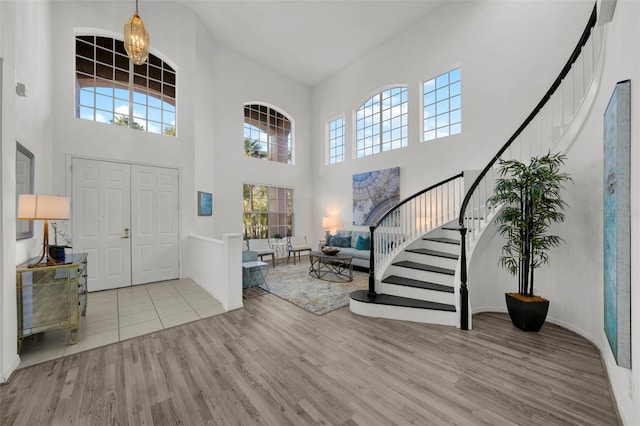 foyer with a chandelier, stairway, and wood finished floors