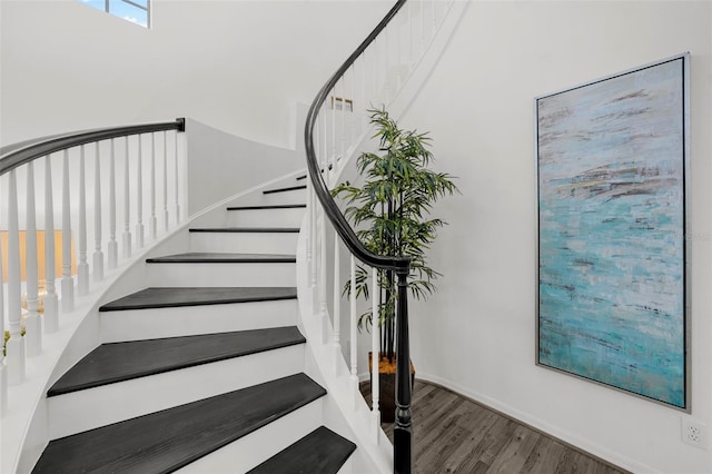 stairs with baseboards and wood finished floors