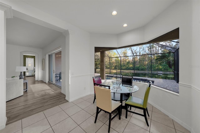 dining area with light tile patterned floors, recessed lighting, baseboards, and a sunroom