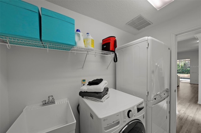 clothes washing area featuring visible vents, washer / clothes dryer, laundry area, and wood finished floors