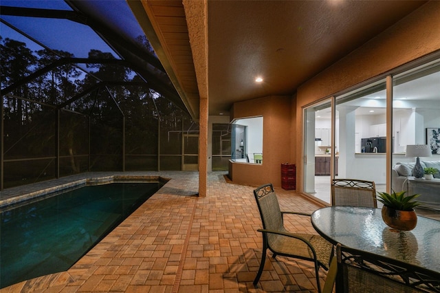 outdoor pool with glass enclosure and a patio area