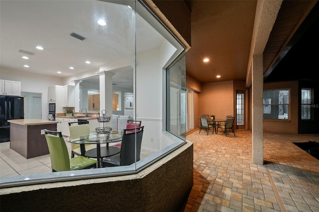 view of patio / terrace featuring a sink, outdoor dining area, and visible vents