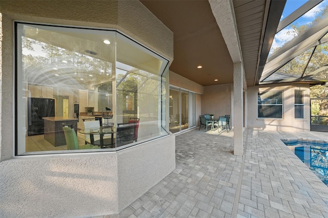 view of patio with an outdoor pool and a lanai