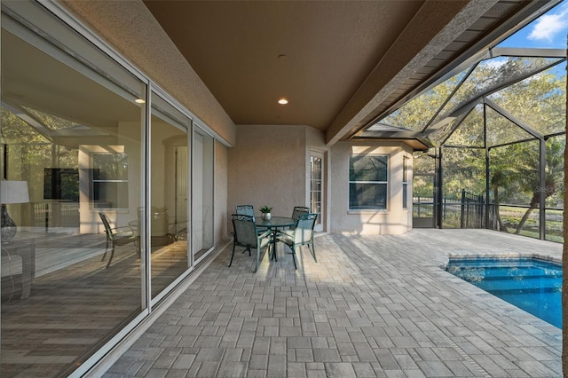 view of patio / terrace featuring glass enclosure and an outdoor pool