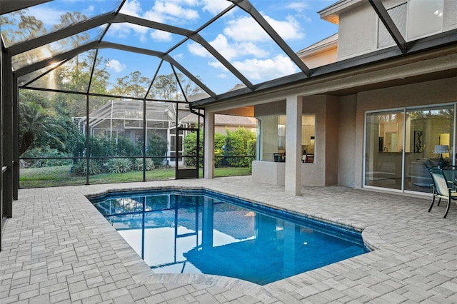 pool featuring glass enclosure and a patio area