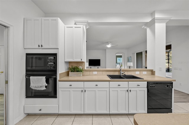 kitchen featuring light tile patterned floors, ceiling fan, a sink, black appliances, and white cabinetry