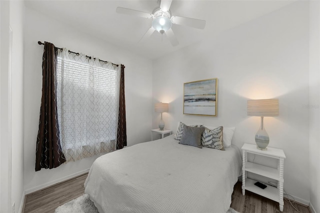 bedroom featuring a ceiling fan, baseboards, and wood finished floors