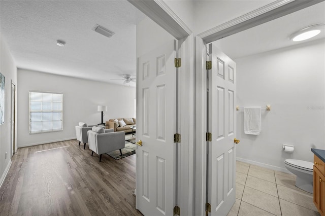 bathroom featuring visible vents, toilet, a textured ceiling, tile patterned flooring, and ceiling fan