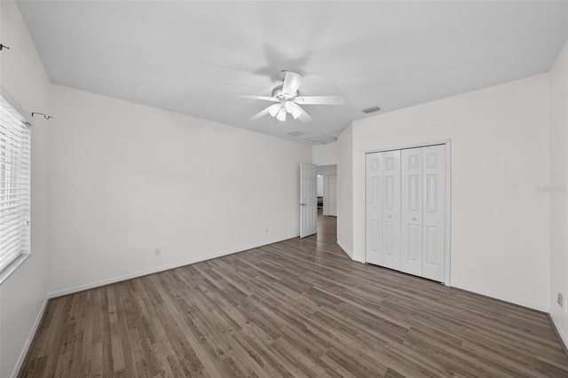 unfurnished bedroom with wood finished floors, baseboards, visible vents, ceiling fan, and a closet