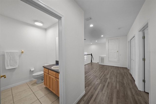 corridor featuring visible vents, an upstairs landing, a sink, recessed lighting, and baseboards