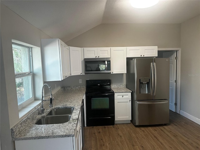 kitchen featuring appliances with stainless steel finishes, a sink, light stone counters, and white cabinets