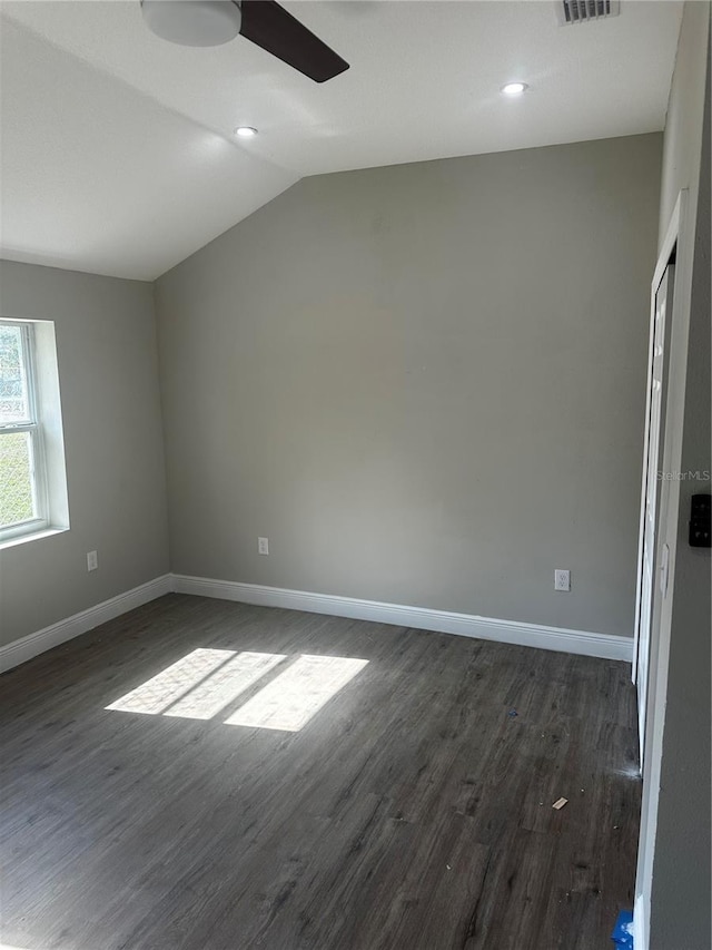 interior space featuring lofted ceiling, ceiling fan, dark wood finished floors, and baseboards