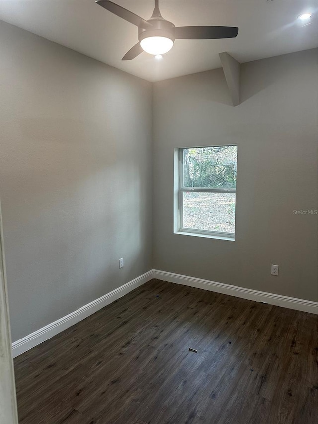 unfurnished room featuring dark wood-style floors, ceiling fan, and baseboards