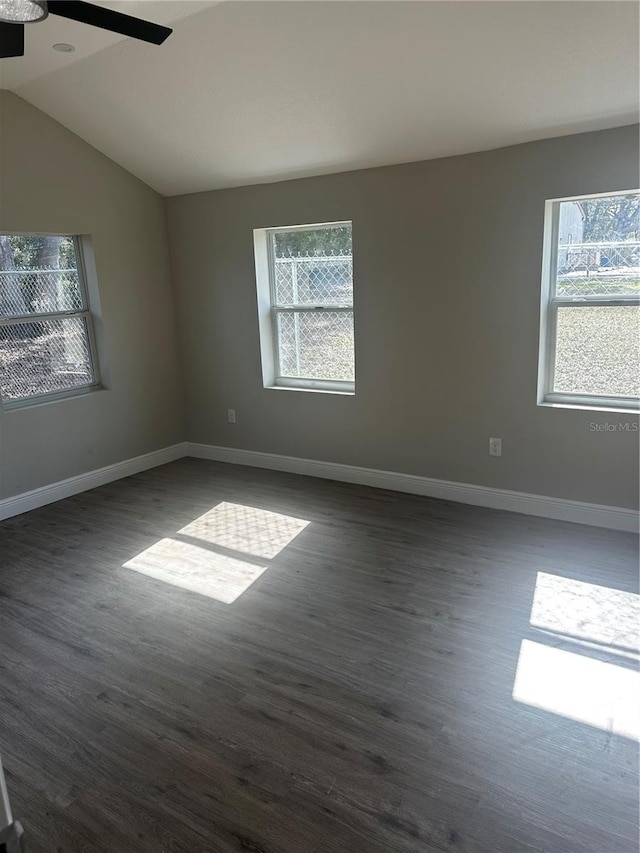 unfurnished room featuring plenty of natural light, baseboards, and dark wood-type flooring