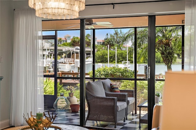 interior space with a water view, a ceiling fan, and tile patterned floors