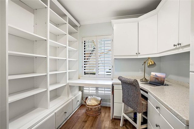 office space featuring dark wood-style floors, built in study area, and crown molding