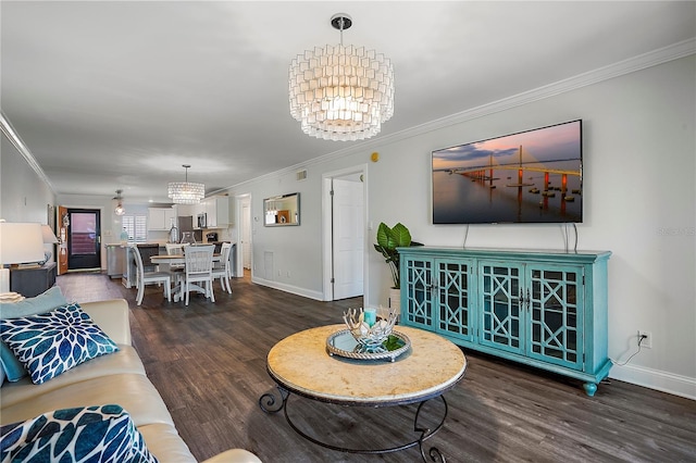 living area featuring baseboards, ornamental molding, dark wood finished floors, and a notable chandelier