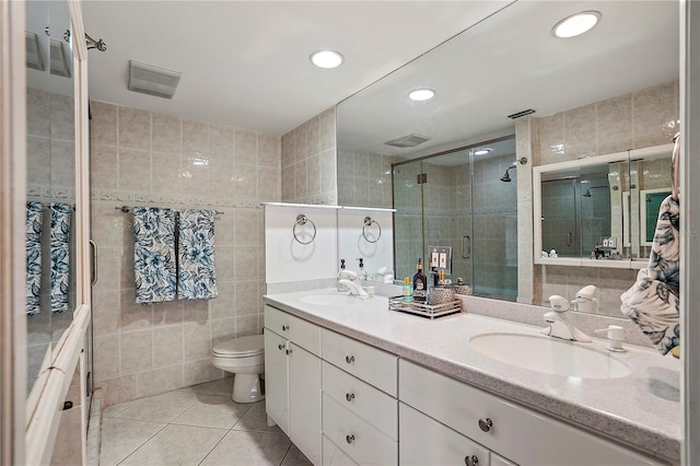 full bath featuring a sink, tile patterned flooring, tile walls, and a shower stall