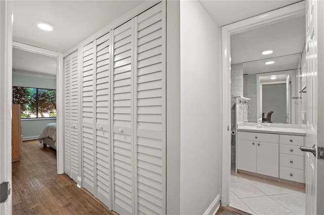 hall with recessed lighting, light wood-style flooring, and baseboards