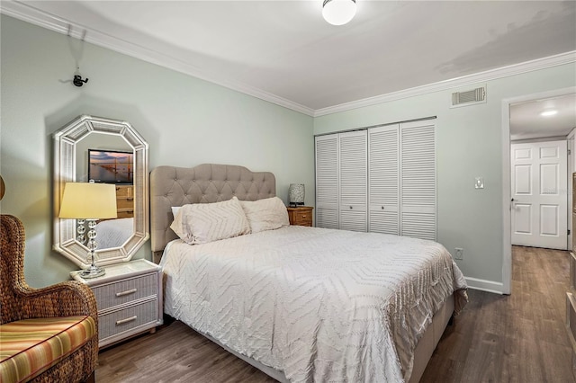 bedroom with crown molding, visible vents, dark wood finished floors, and a closet