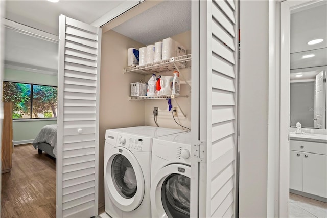 laundry area with laundry area, separate washer and dryer, and light wood-style flooring