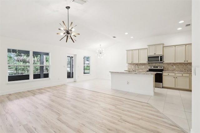 kitchen with open floor plan, decorative light fixtures, vaulted ceiling, stainless steel appliances, and a chandelier