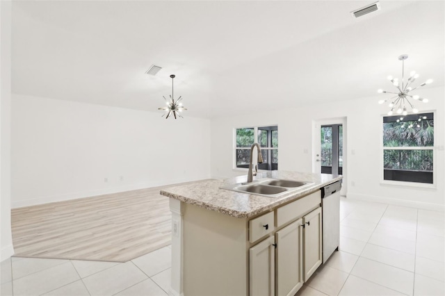 kitchen with a notable chandelier, stainless steel dishwasher, open floor plan, a kitchen island with sink, and a sink