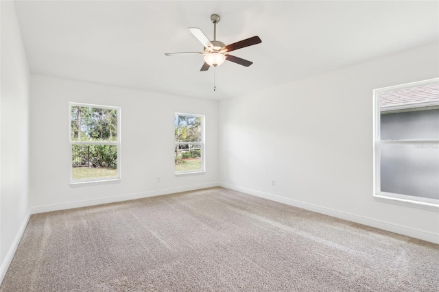 spare room with carpet, baseboards, and ceiling fan