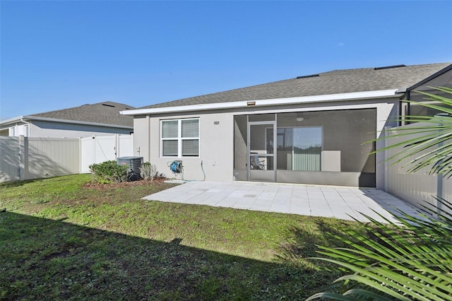 rear view of property featuring central air condition unit, a yard, stucco siding, a patio, and fence