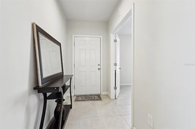 hall with light tile patterned flooring, baseboards, and visible vents