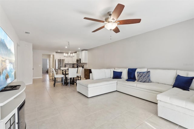 living area featuring visible vents, recessed lighting, light tile patterned flooring, and ceiling fan with notable chandelier