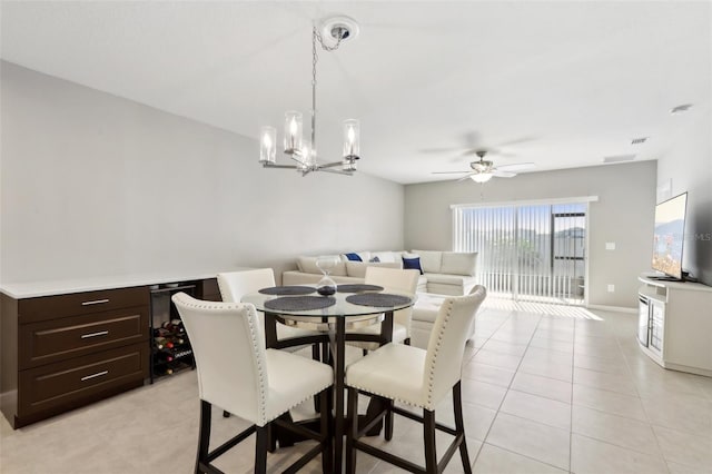 dining room with light tile patterned floors, visible vents, ceiling fan with notable chandelier, and baseboards