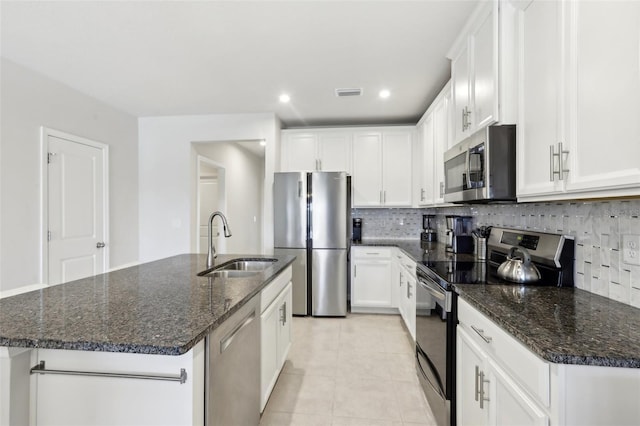 kitchen featuring white cabinetry, visible vents, decorative backsplash, stainless steel appliances, and a sink