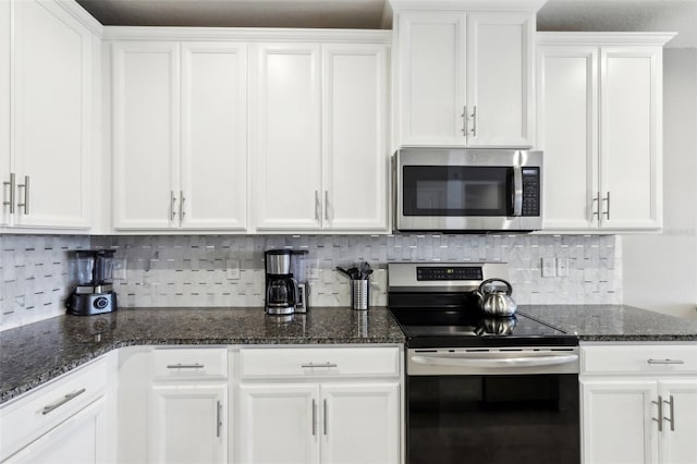 kitchen featuring white cabinetry, decorative backsplash, dark stone counters, and appliances with stainless steel finishes