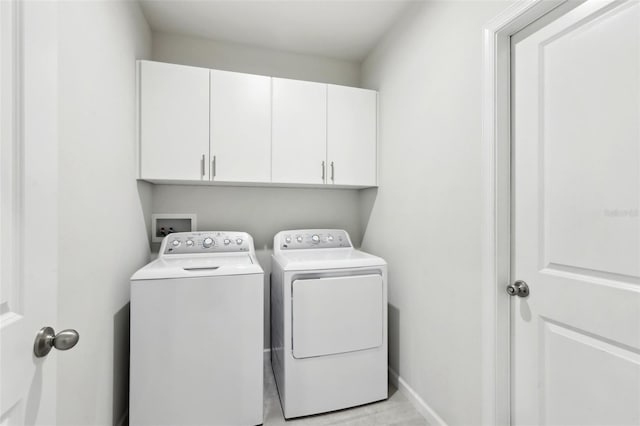 laundry area featuring cabinet space, baseboards, and separate washer and dryer