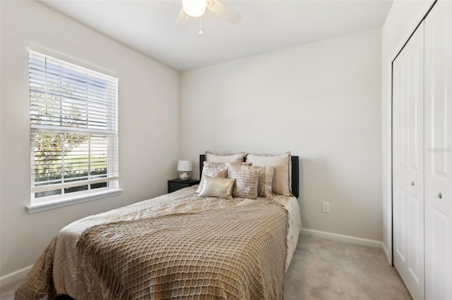 carpeted bedroom featuring a closet, baseboards, and ceiling fan