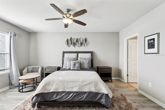 bedroom with light wood finished floors, baseboards, and ceiling fan