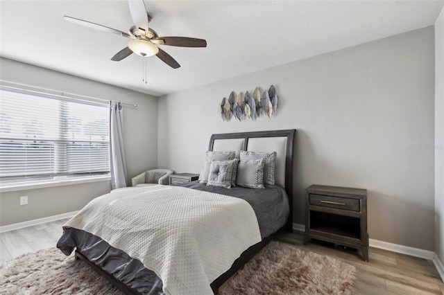 bedroom featuring baseboards, a ceiling fan, and wood finished floors
