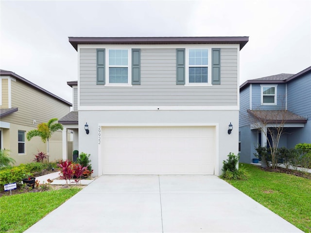 traditional-style home featuring a garage, driveway, and stucco siding