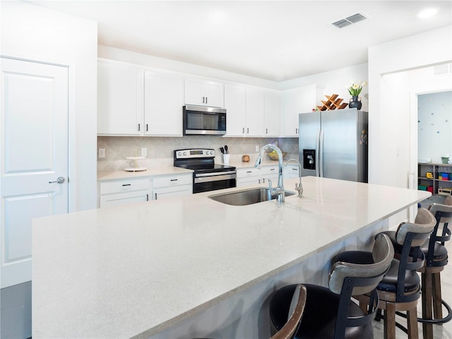 29922 Marquette Ave, Wesley Chapel, FL 33545 - kitchen featuring stainless steel appliances, visible vents, a sink, and decorative backsplash