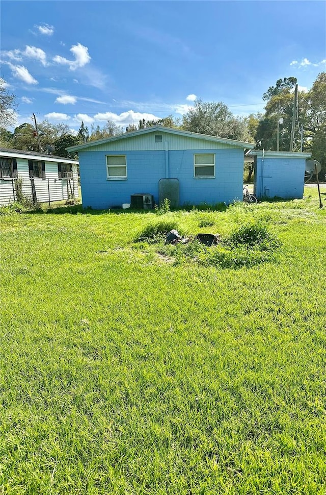 954 Fordson Ave, Labelle, FL 33935 - back of house featuring a yard, concrete block siding, and central AC unit