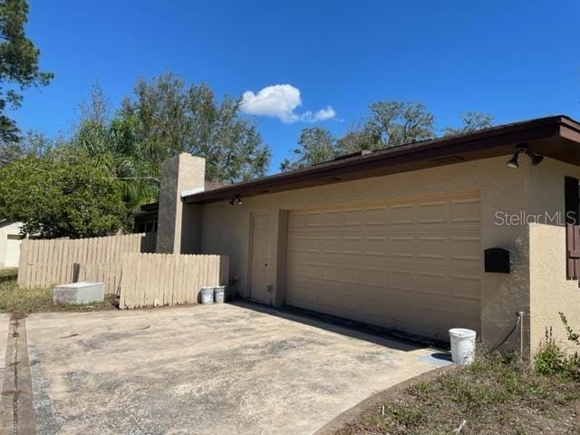 garage with driveway and fence