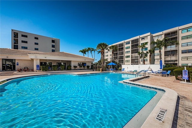 pool with a patio area and fence