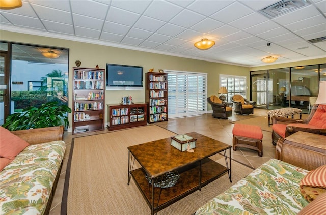 living area featuring tile patterned flooring, a paneled ceiling, and visible vents