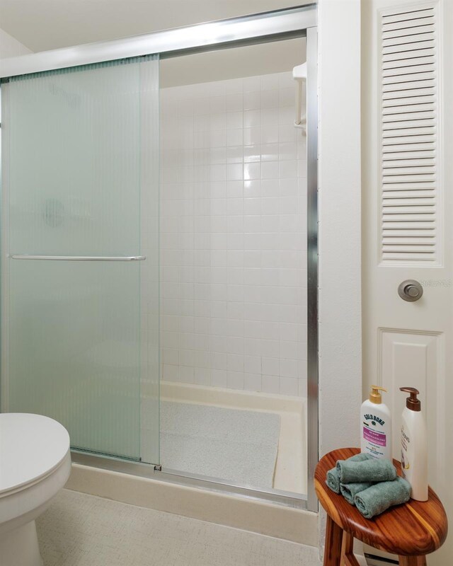 bathroom with toilet and a shower stall