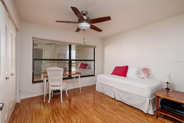 bedroom with light wood-style flooring, a ceiling fan, a closet, and baseboards