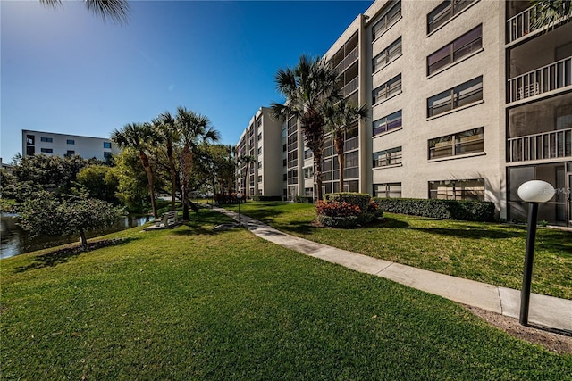 view of community featuring a lawn and a water view