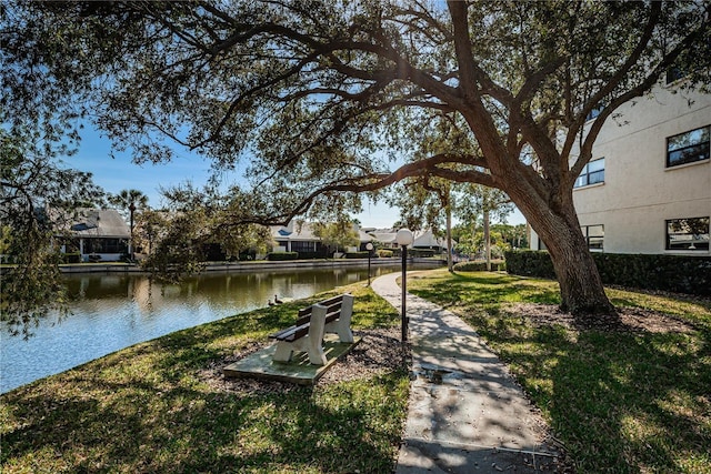 view of home's community with a lawn and a water view