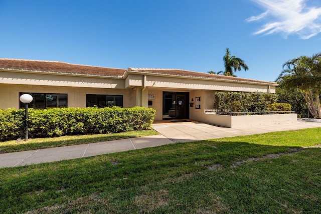 view of front of home featuring stucco siding and a front lawn