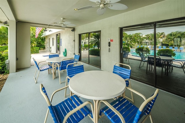 view of patio / terrace with outdoor dining area, a ceiling fan, and a community pool